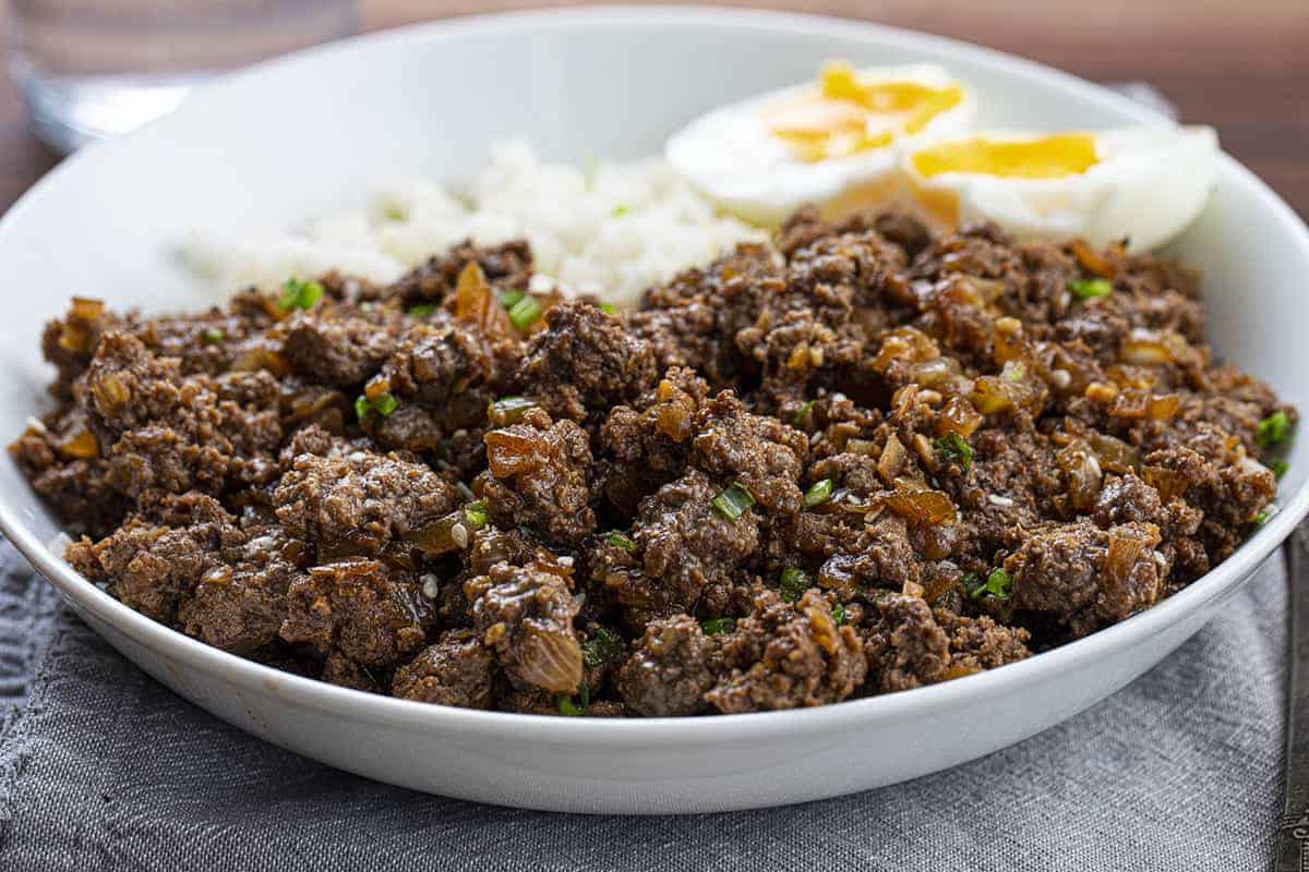 Close up showing Beef Bulgogi in White Bowl on Blue Napkin