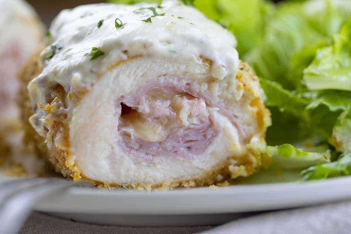 Very Close Up of Inside of Chicken Cordon Bleu on Plate with Lettuce