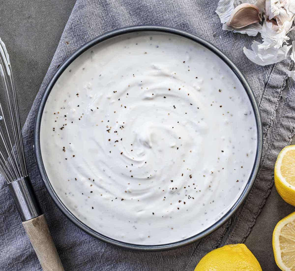 Garlic Sauce in a Bowl Shot from Overhead with Lemons