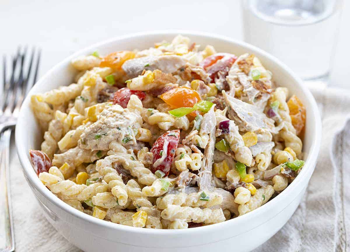 BIg Bowl of Chicken Bacon Ranch Salad on White Towel with Water and Forks