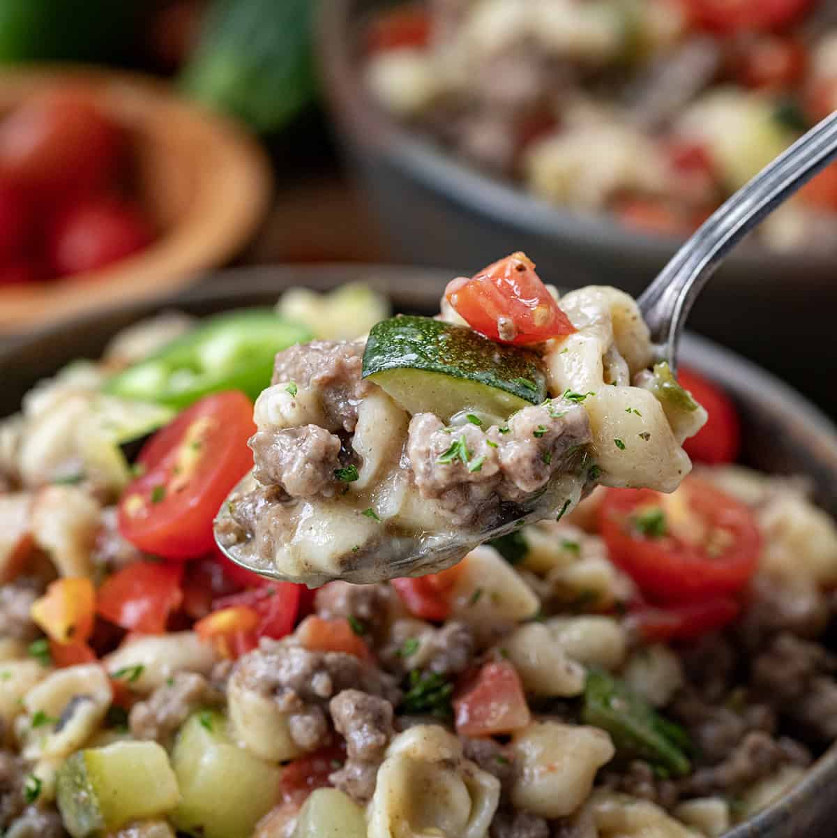 Spoonful of Summer Goulash being held in front of the bowl close up.