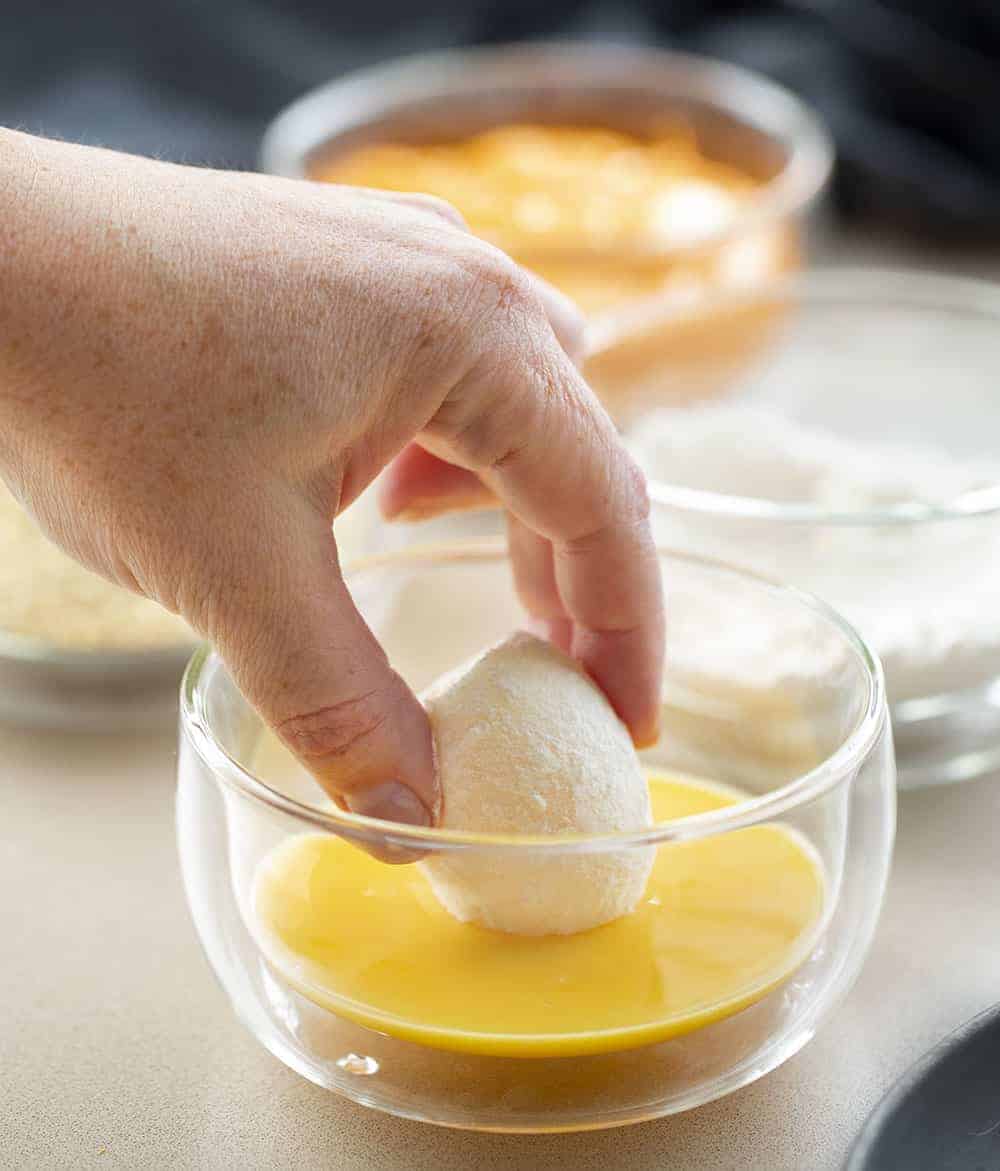 Dipping Flour Coated Soft Boiled Egg into Raw Egg and then other Batters for Deep Fried Buffalo Eggs