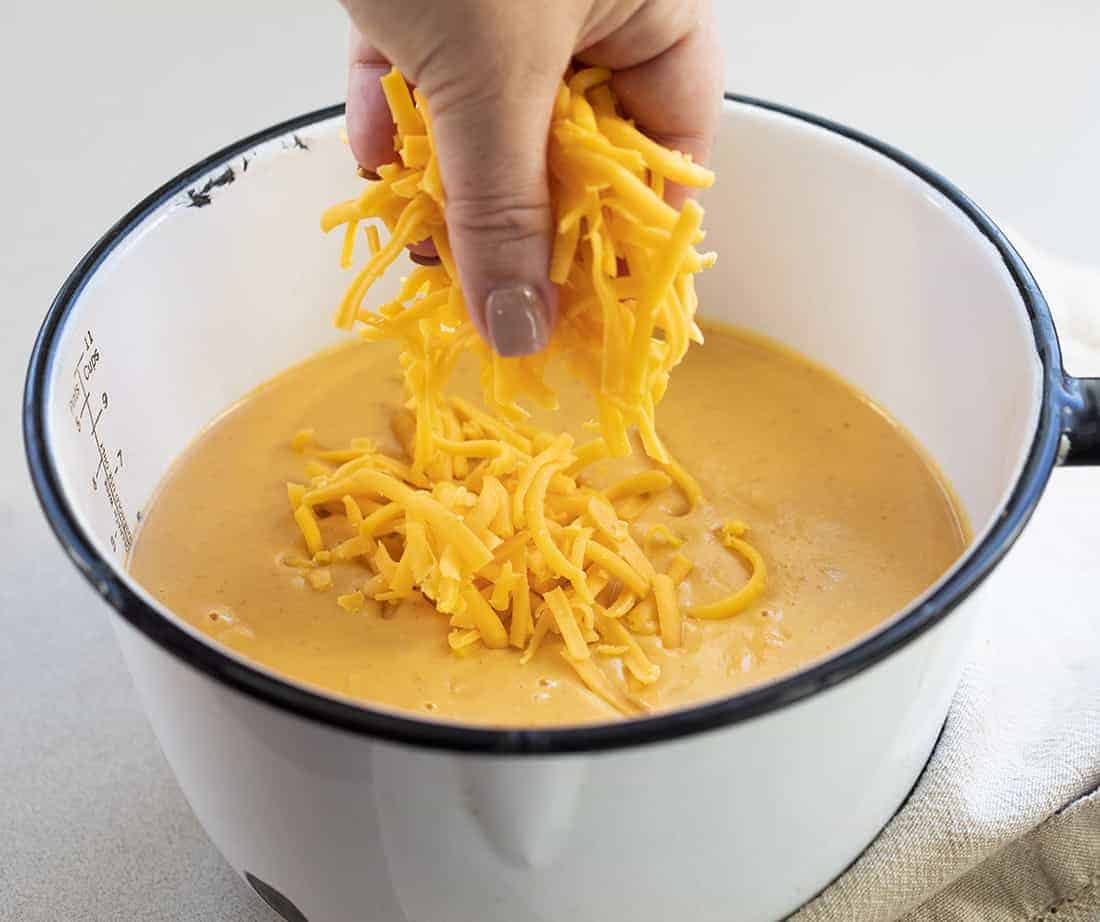 Adding Cheese to Mixture for Pumpkin Macaroni and Cheese Recipe