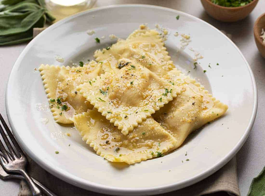 Homemade Pumpkin Ravioli with Garlic Brown Butter on White Plate