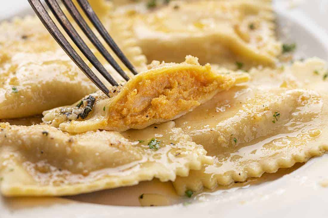 Cut Into Homemade Pumpkin Ravioli with Garlic Brown Butter Showing Inside Texture