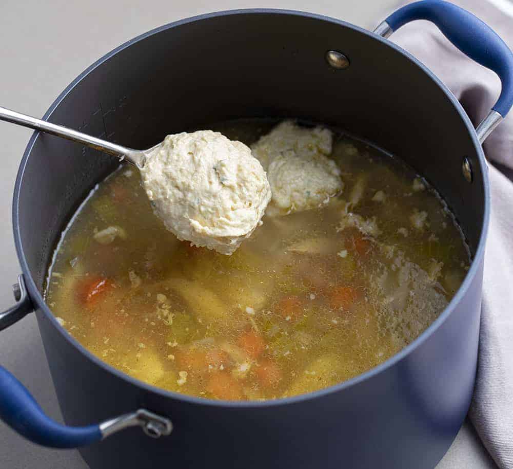 Adding Dumplings to Old Fashioned Chicken and Dumplings in a Blue Pot