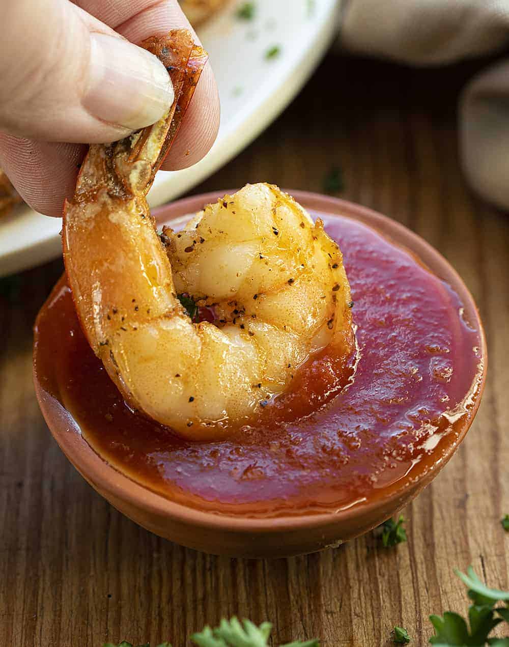 Dipping Air Fryer Shrimp into Cocktail Sauce.