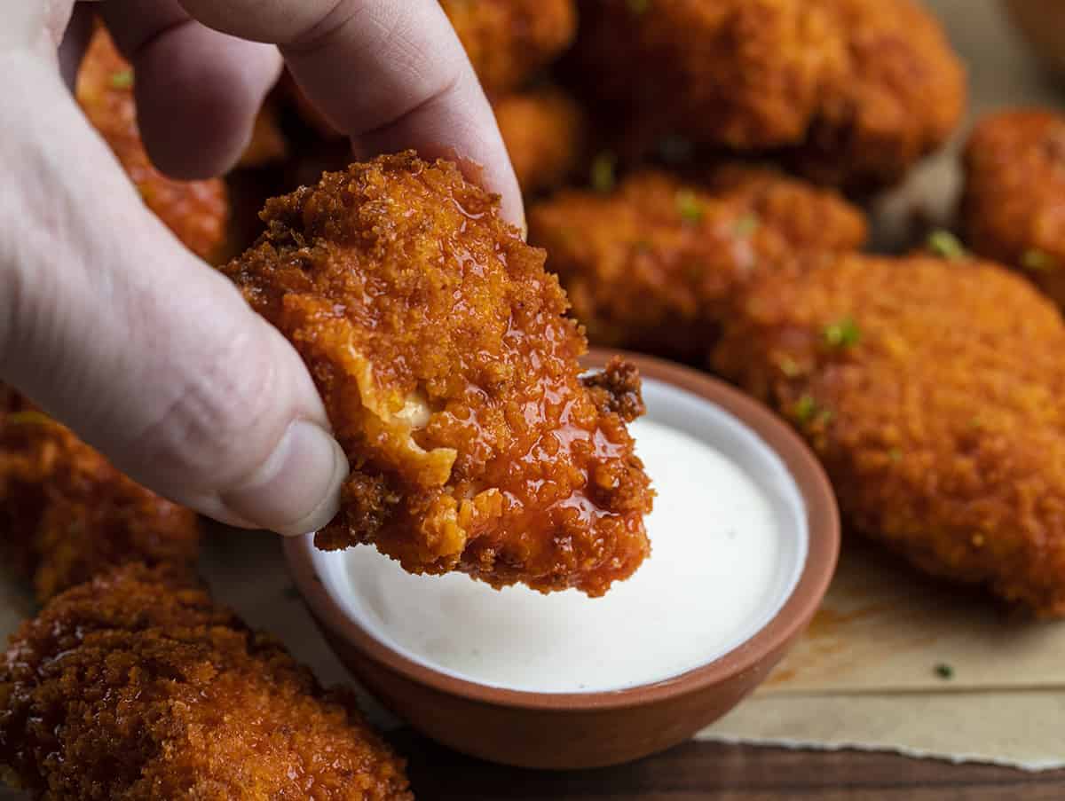 Hand Dipping Air Fryer Buffalo Chicken Nuggets into Ranch