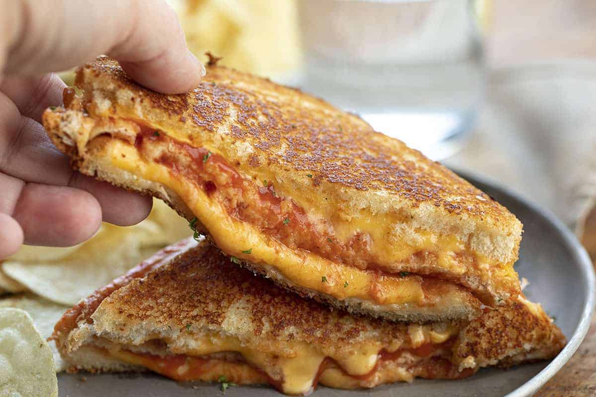 Hand Picking up Triple Decker Tomato Grilled Cheese