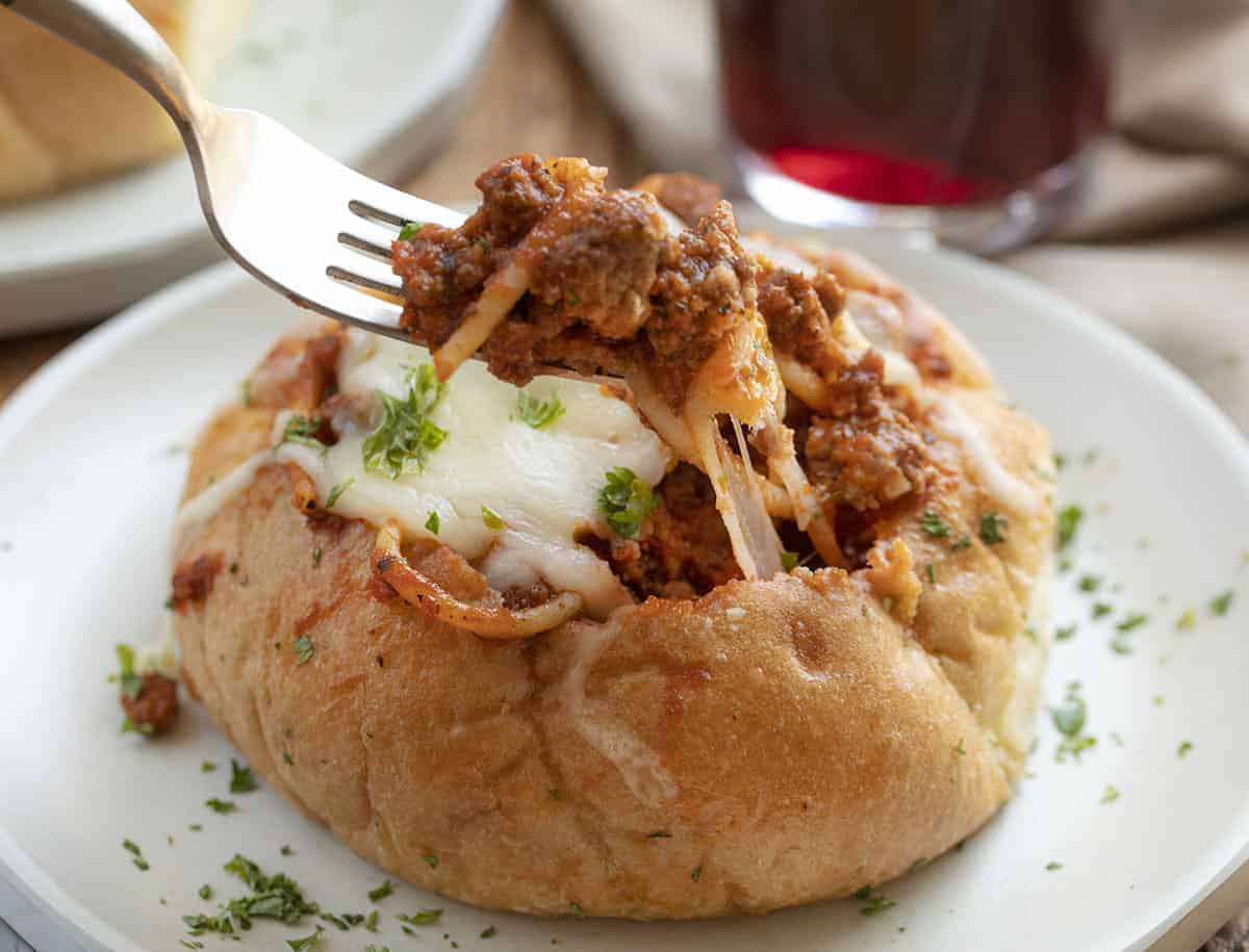Fork taking a bite out of Bread Bowl Spaghetti