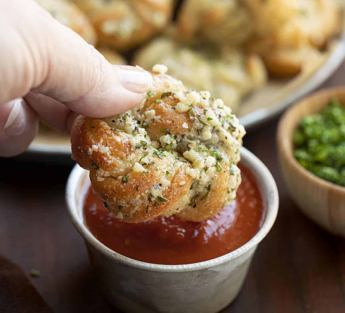 Hand Dipping Garlic Knots in Sauce