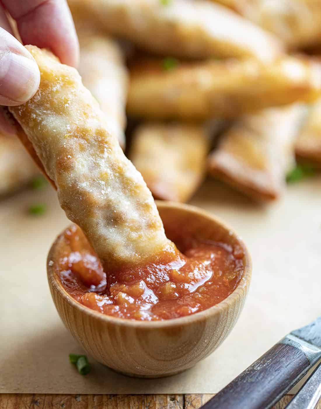 Dipping Breakfast Taquitos into Salsa