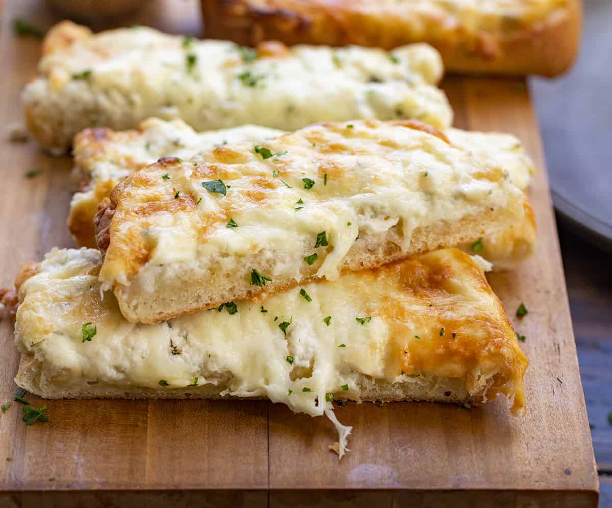 Cut up Pieces of 3 Cheese Garlic Bread on a Cutting Board