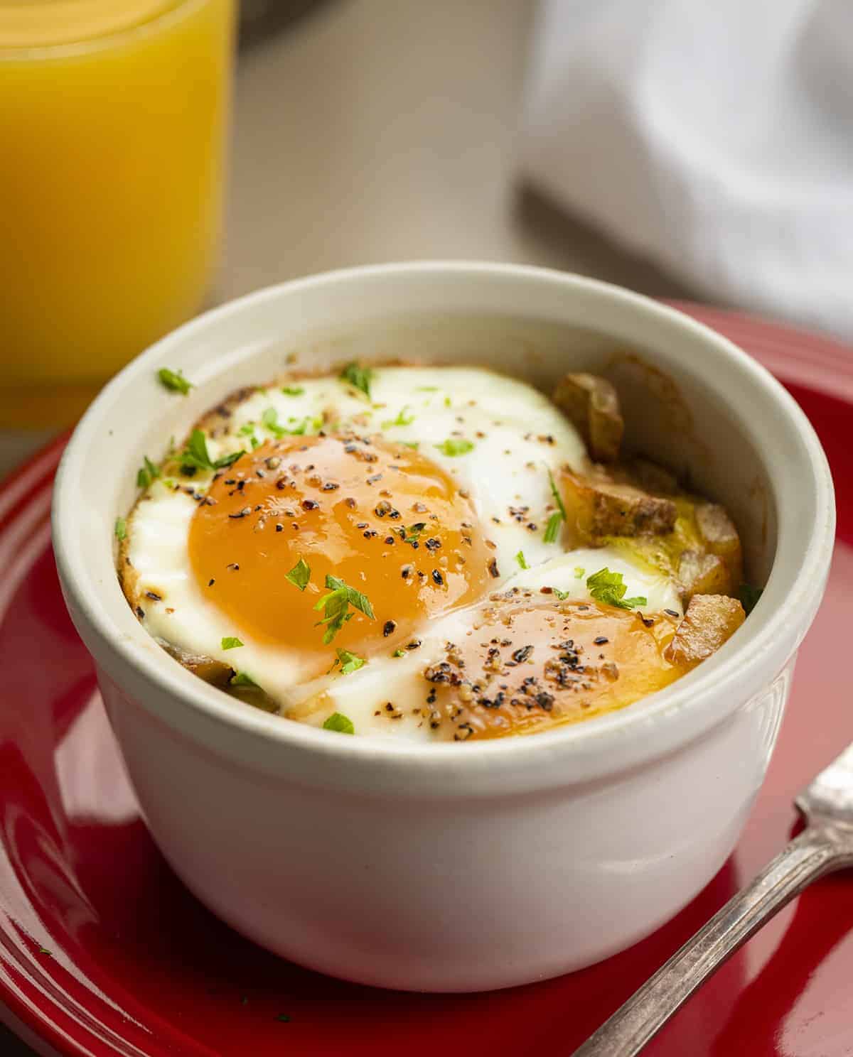 Baked Eggs- Eggs in a Cup - Shirred Eggs - Snug Eggs in a Cup on a Red Plate