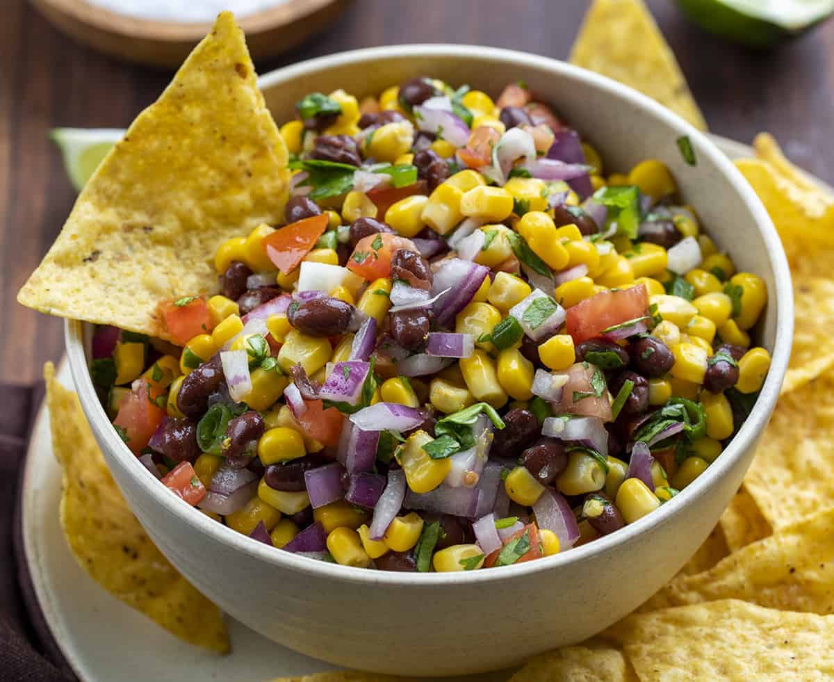Bowl of Black Bean Corn Salsa with a Chip in It