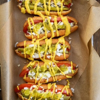 Chicago Style Corn Dogs on a Try with Brown Parchment Paper Lined up Next to each Other.