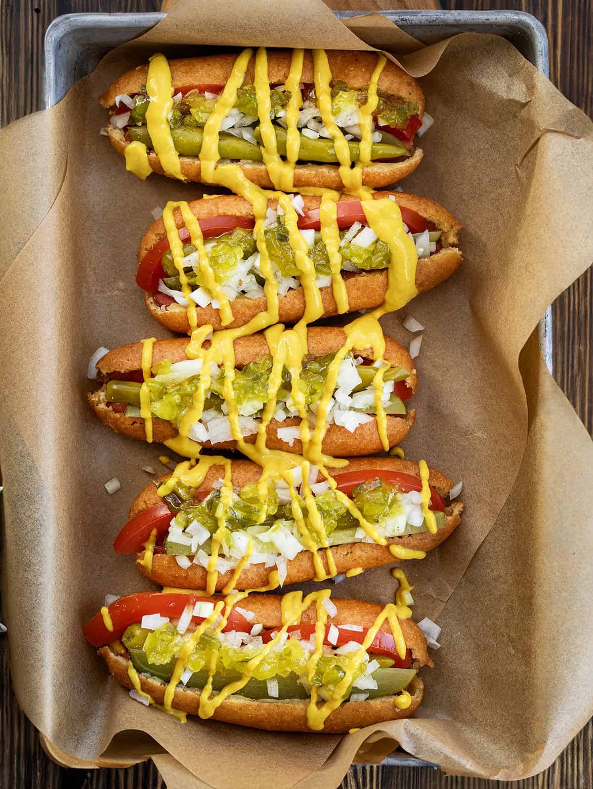 Chicago Style Corn Dogs on a Try with Brown Parchment Paper Lined up Next to each Other.