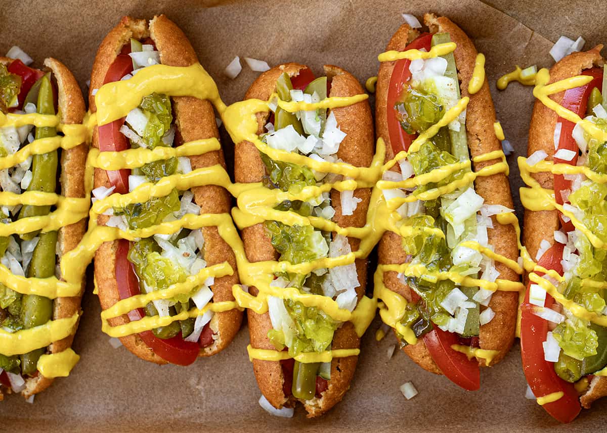 Chicago Style Corn Dogs on a Try with Brown Parchment Paper Lined up Next to each Other.