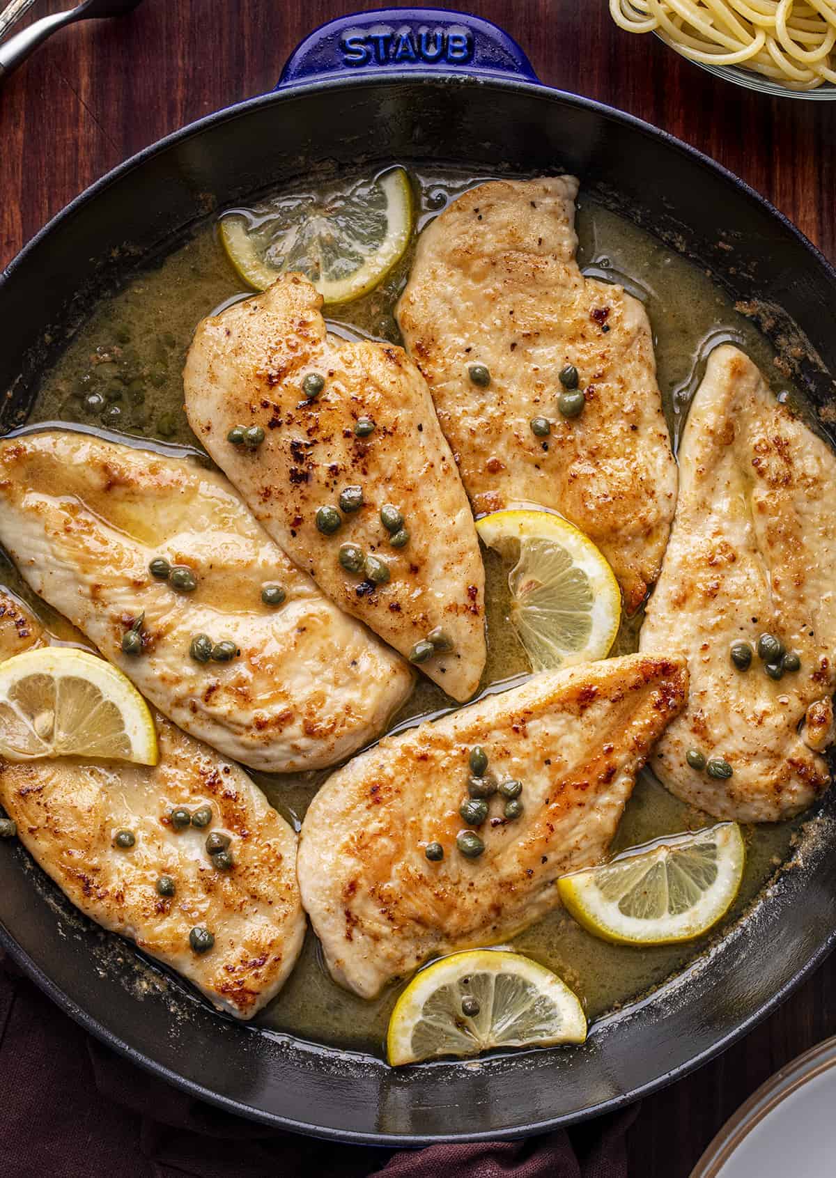 Skillet of Chicken Piccata from Overhead on a Cutting Board
