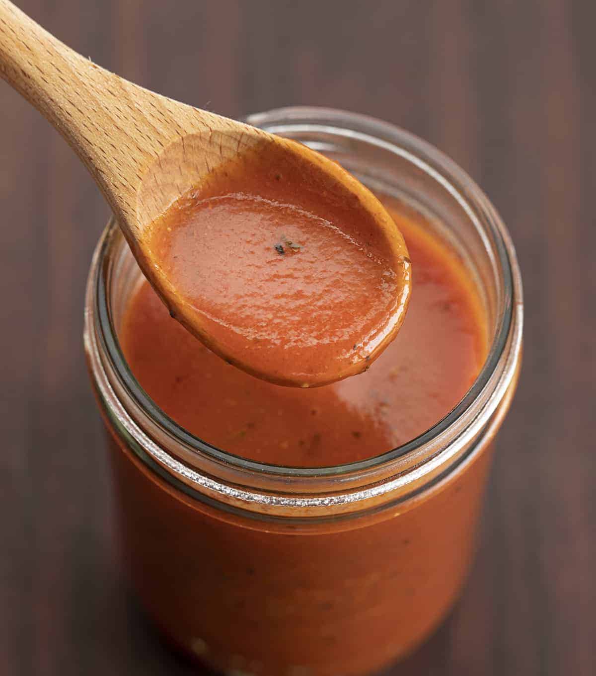 Spoon with Easy Enchilada Sauce on it Lifting Sauce up from a Jar