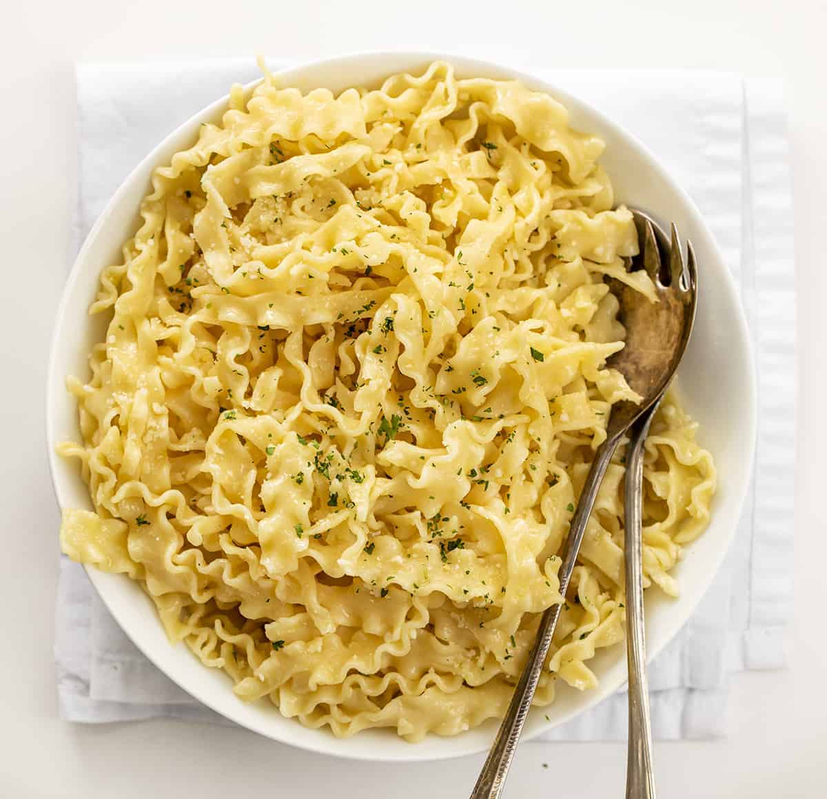 Big Bowl of Butter Noodles with Utensils on Napkin