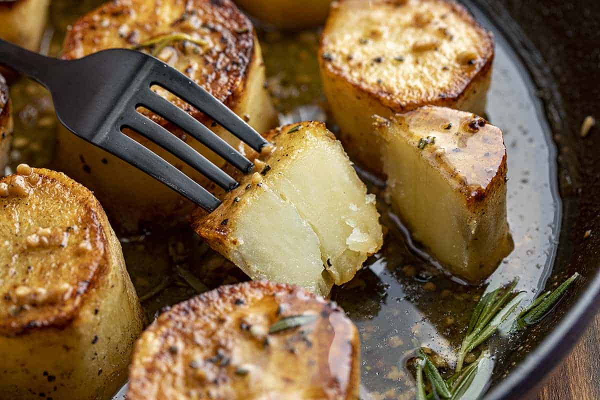 Fork poking Fondant Potatoes - Melting Potatoes showing tender inside