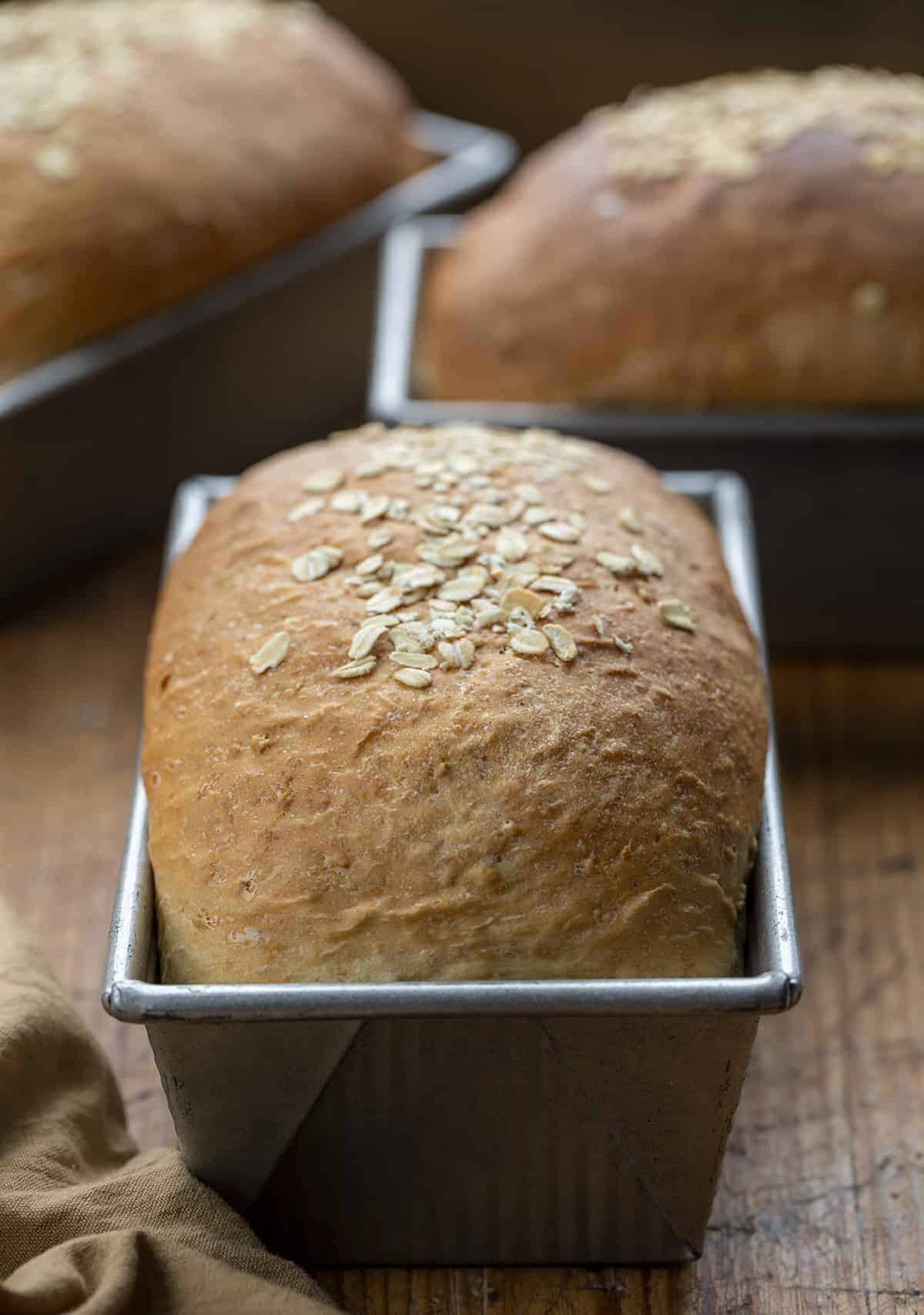 Loaves of Bread on Cutting Board for Big Batch Honey Oat Bread Recipe