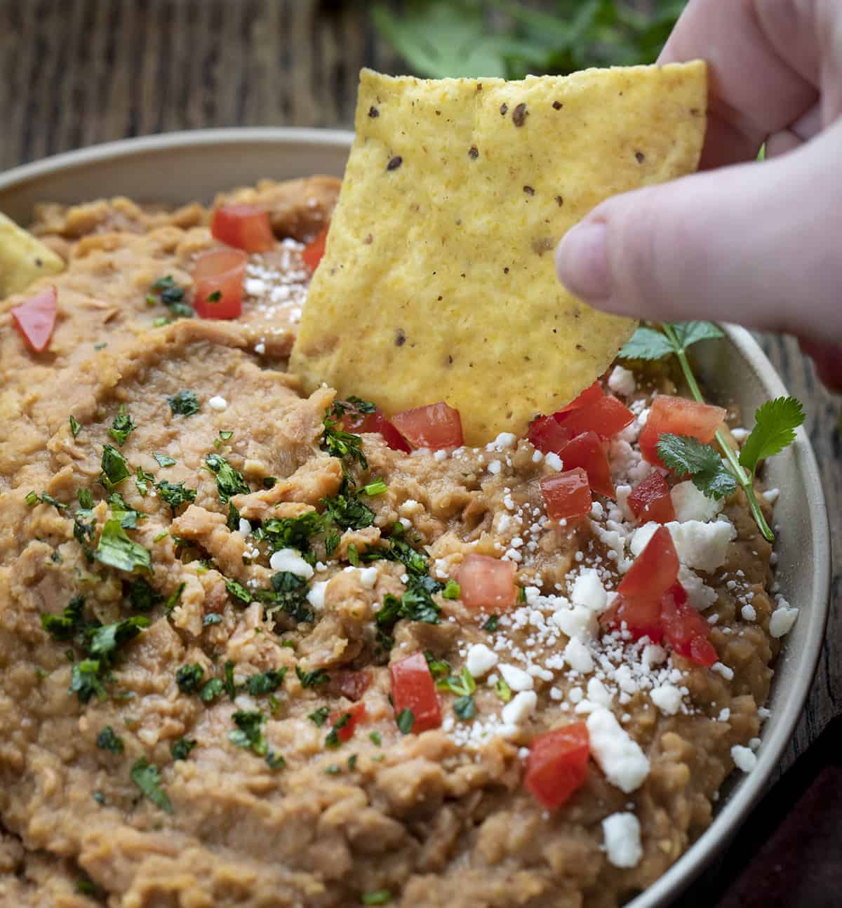Dipping Tortilla Chip into Refried Beans 