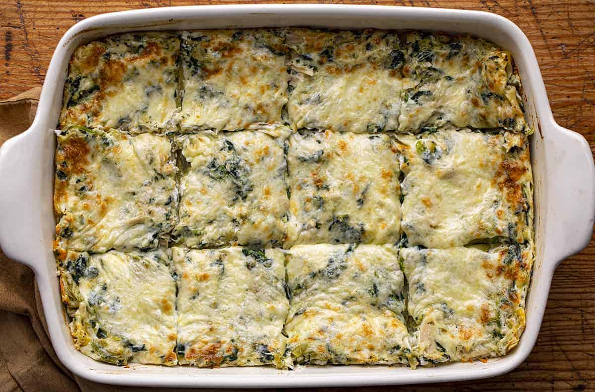 Overhead of a Pan of Cooked and Sliced Cheesy Spinach and Artichoke Lasagna.