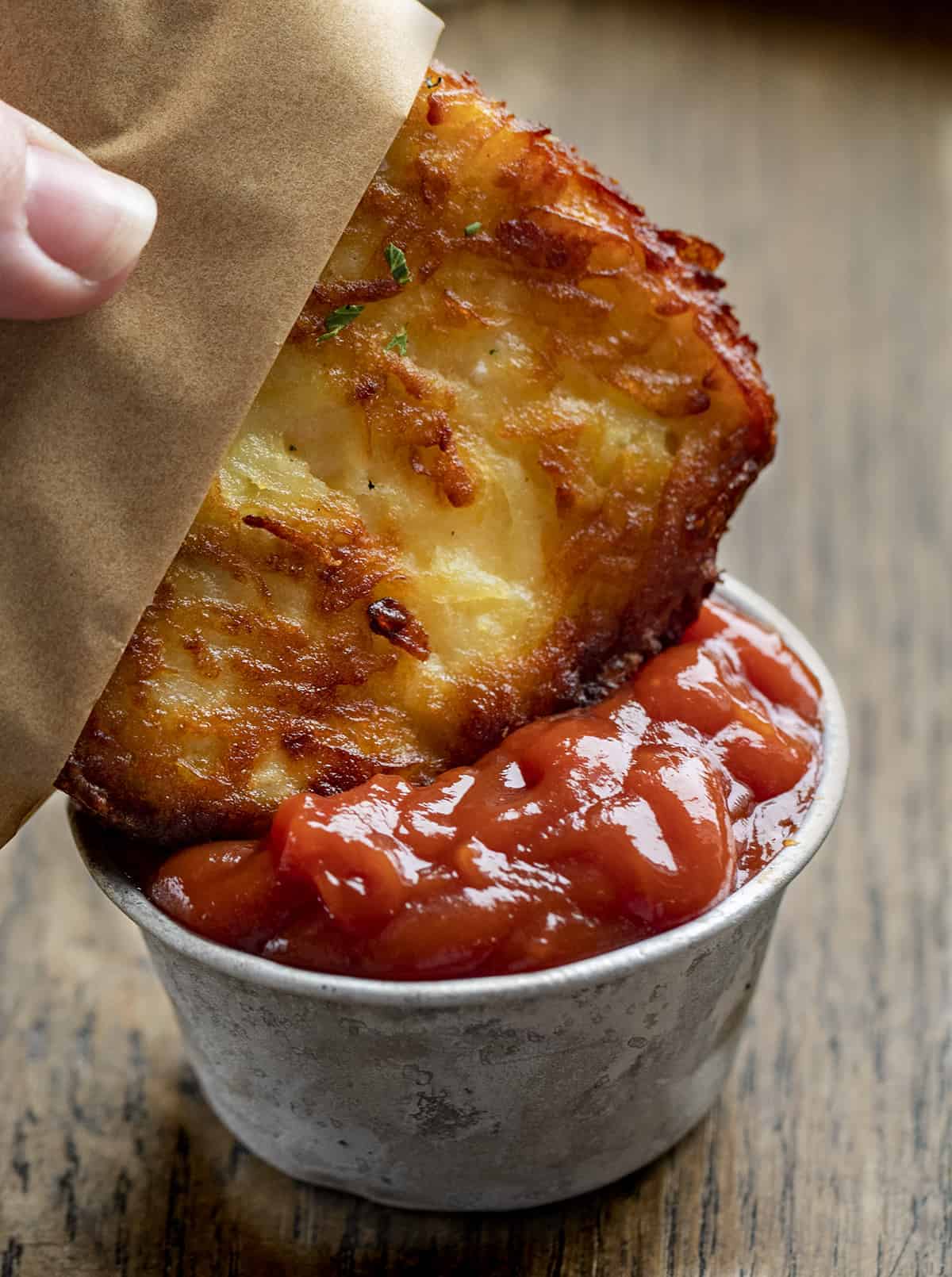 Dipping a Homemade Hash Brown Patty into Ketchup