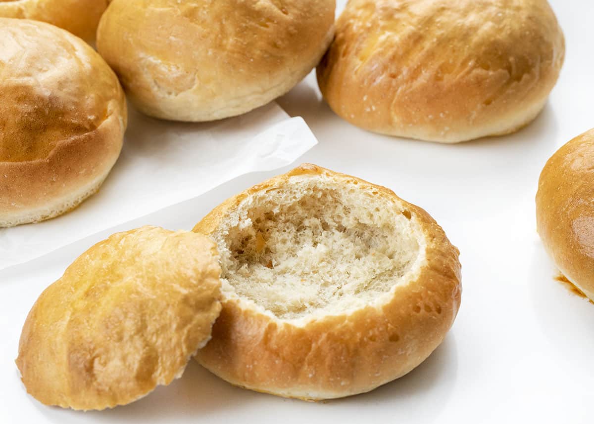 Bread Bowls one a Counter With One Cut Into and Hallowed Out.