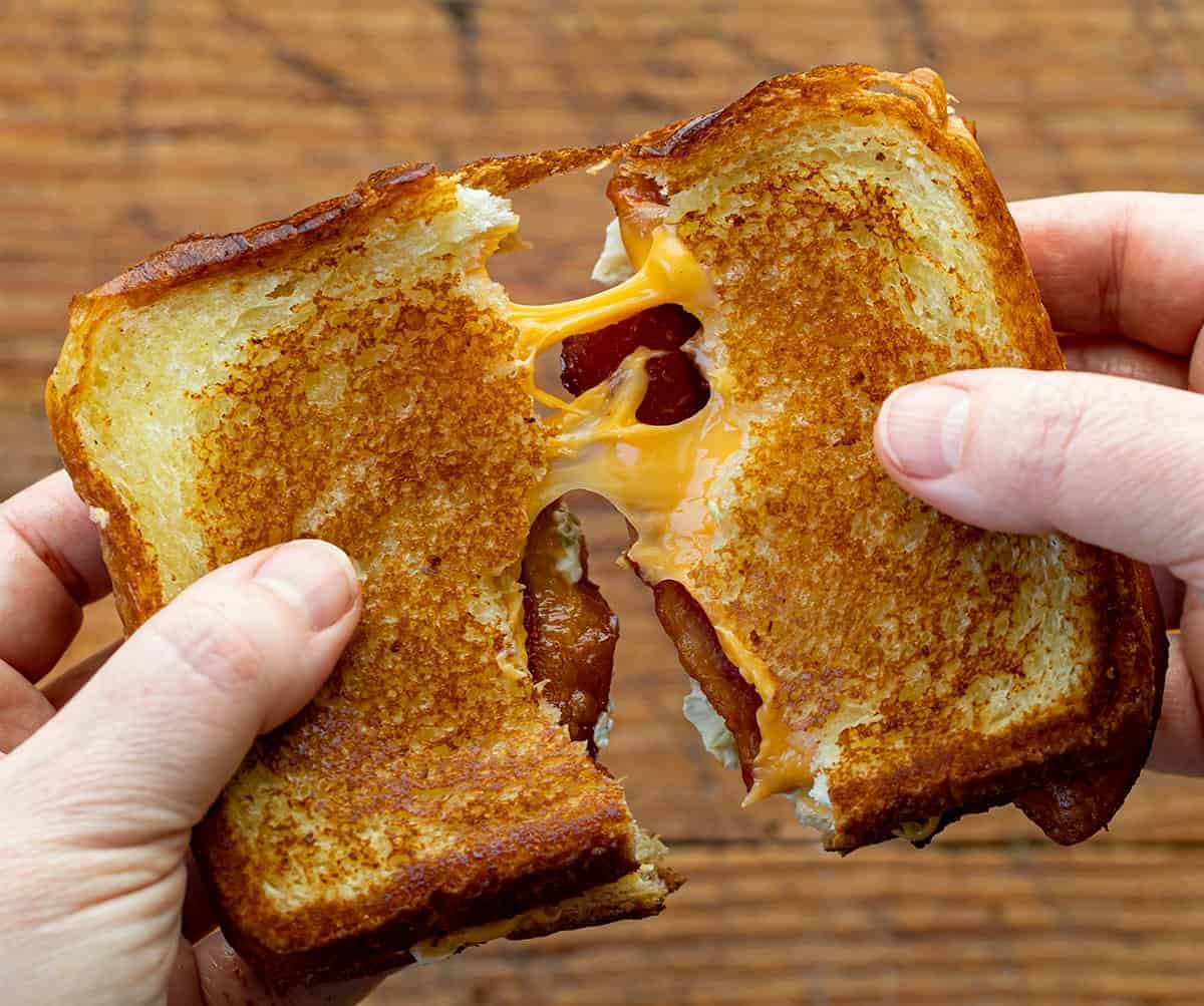 Hand Pulling Apart a Roasted Jalapeno Popper Grilled Cheese Sandwich