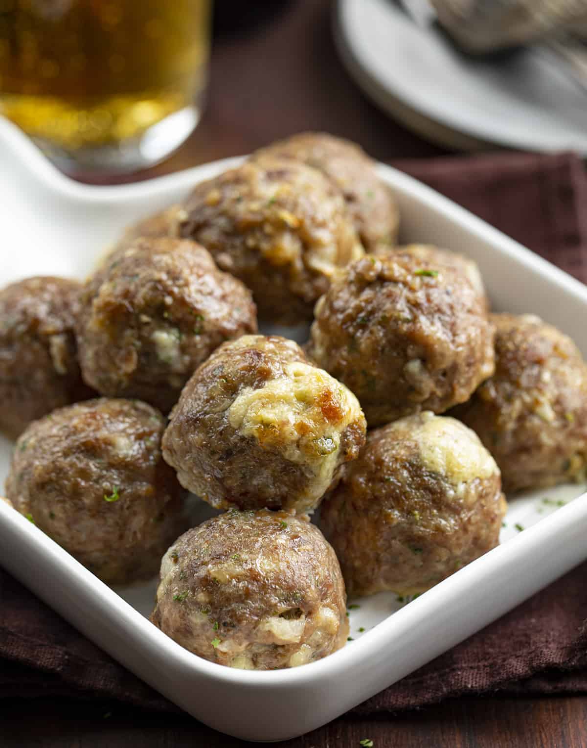 Pan of Jalapeno Popper Stuffed Meatballs with Beer in the Background