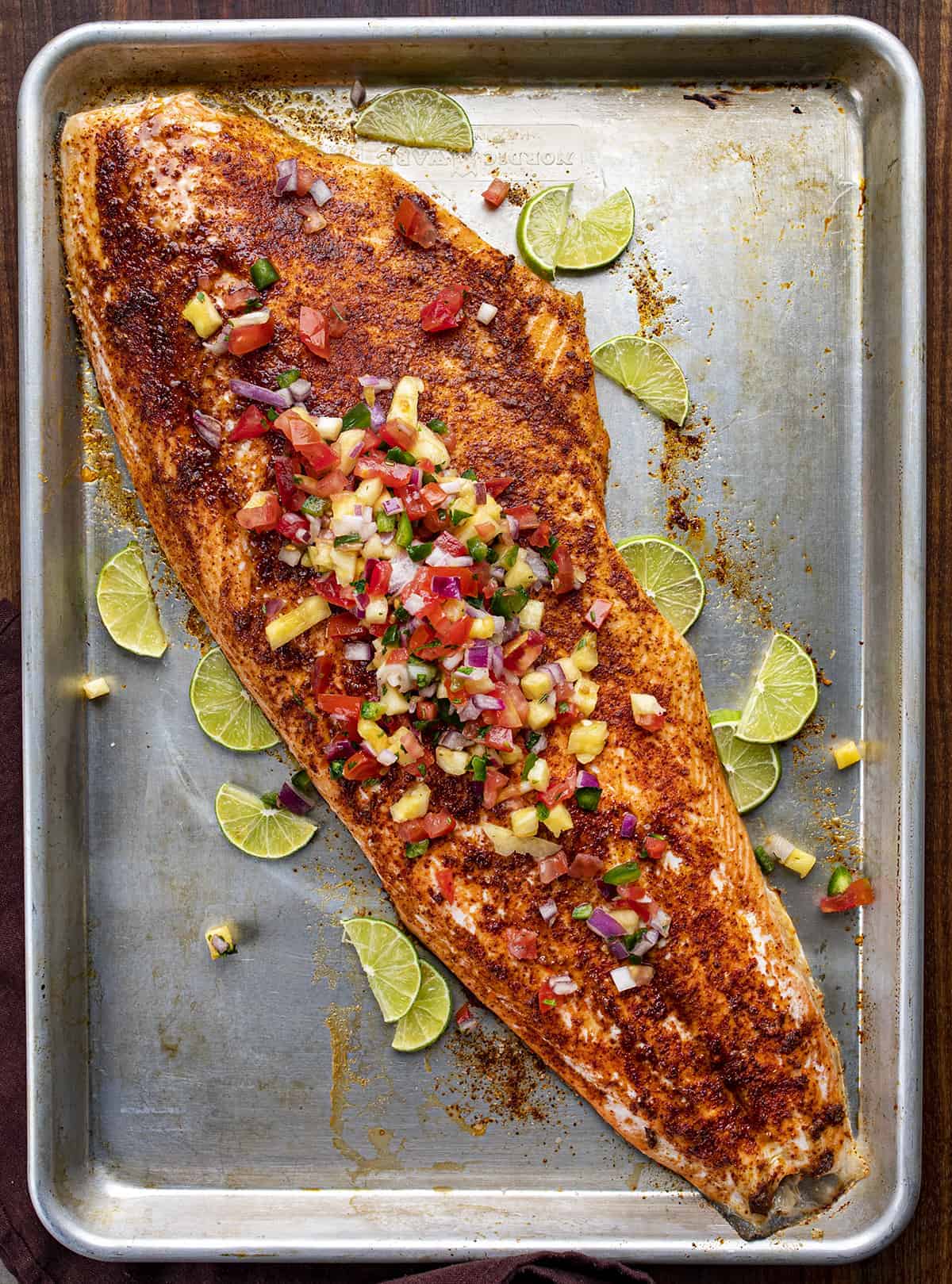 Chili Lime Salmon with Pineapple Salsa on a Pan from Overhead with Limes