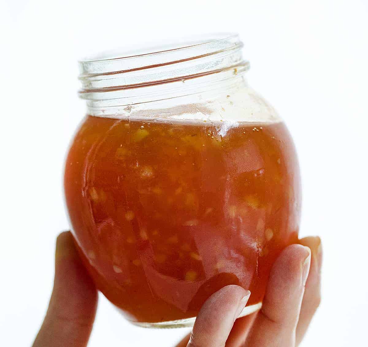 Hand Holding Jar of Homemade Sweet Chili Sauce.