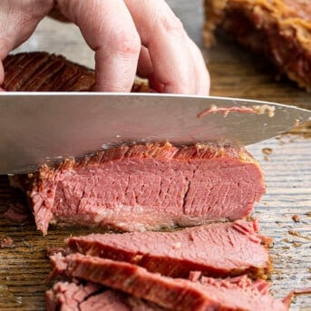 Hand Using Knife to Cut Corned Beef Slices