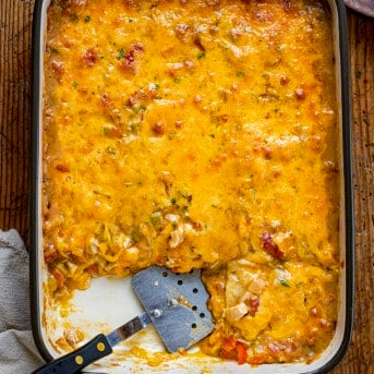 Overhead of a Casserole Pan of King Ranch Chicken with Pieces Removed and Spatula in Pan