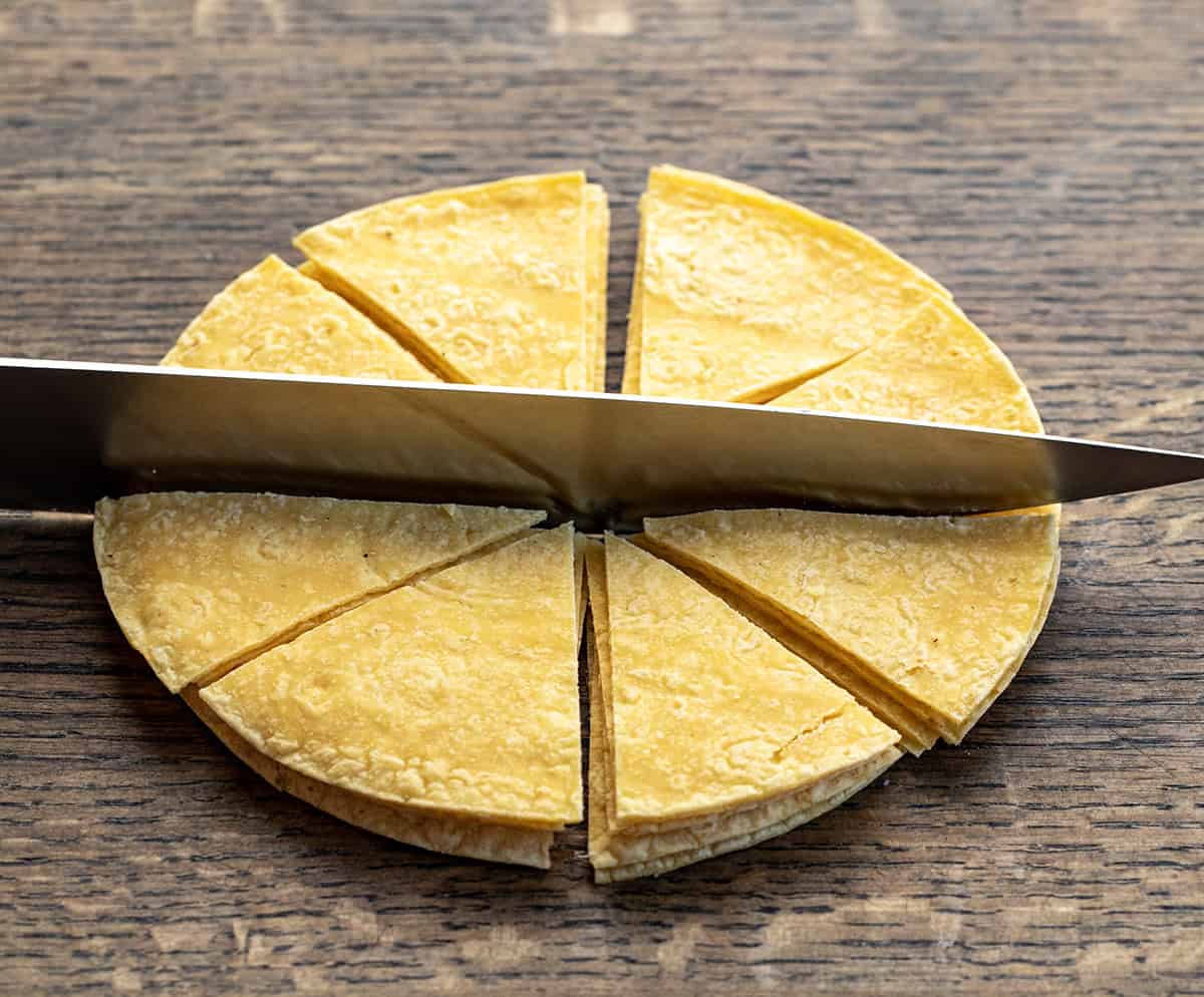 Cutting tortillas into triangles to make Tortilla Chips.