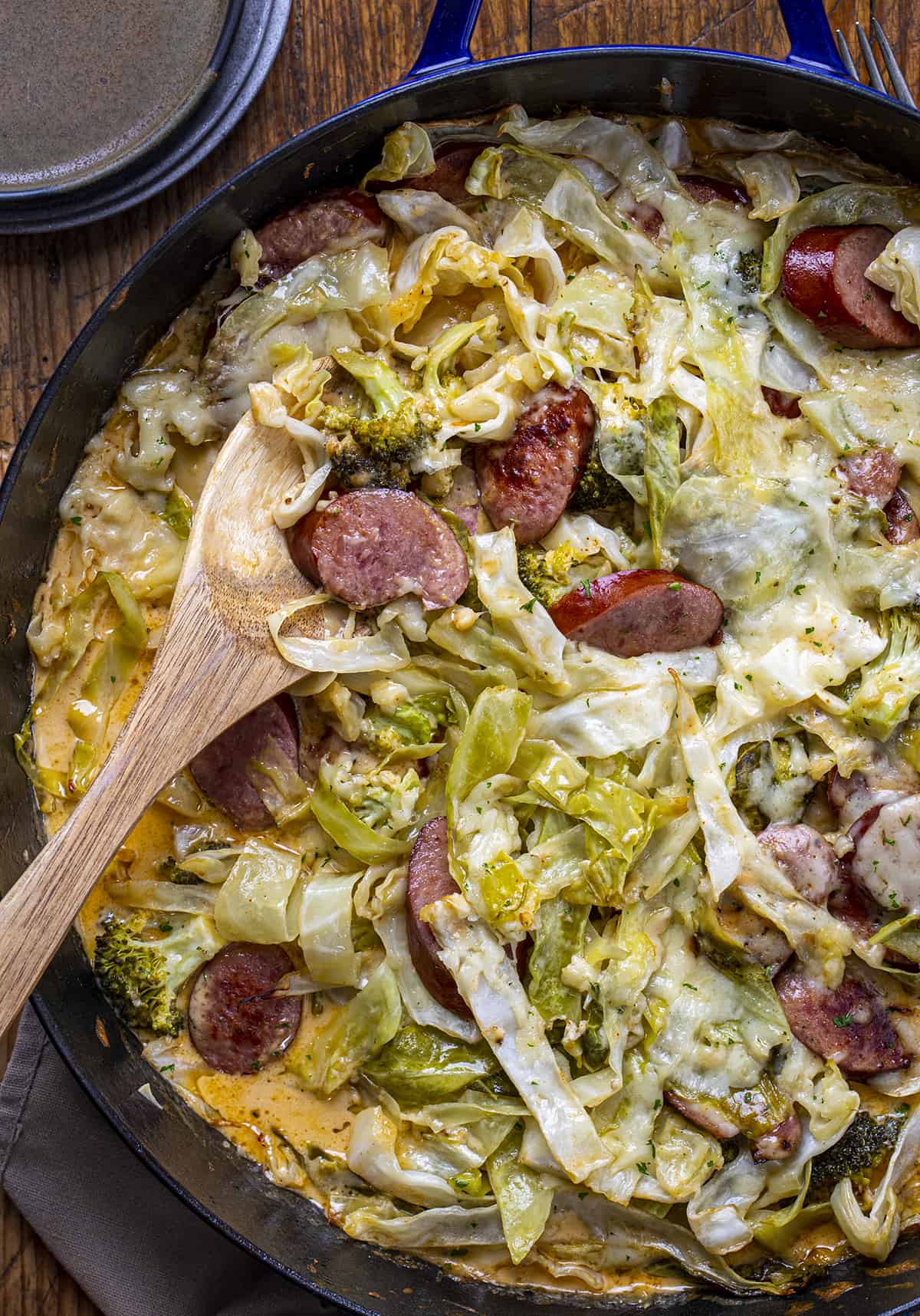 Cheesy Sausage Cabbage Broccoli Bake in a Skillet with a Wooden Spoon. Dinner, Cabbage Recipes, Fried Cabbage, Sausage and Cabbage, Polish Sausage Recipes, Summer Sausage Recipes, Kielbasa Recipes, i am homesteader, iamhomesteader