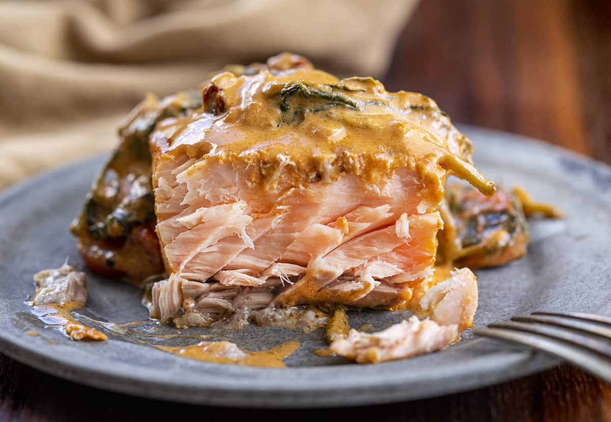 Piece of Creamy Tuscan Salmon Cut Into Showing Inside. Salmon Recipes, Dinner, Supper, How to Cook Salmon, Comfort Food, dinner recipes, salmon tuscan, i am homesteader, iamhomesteader.