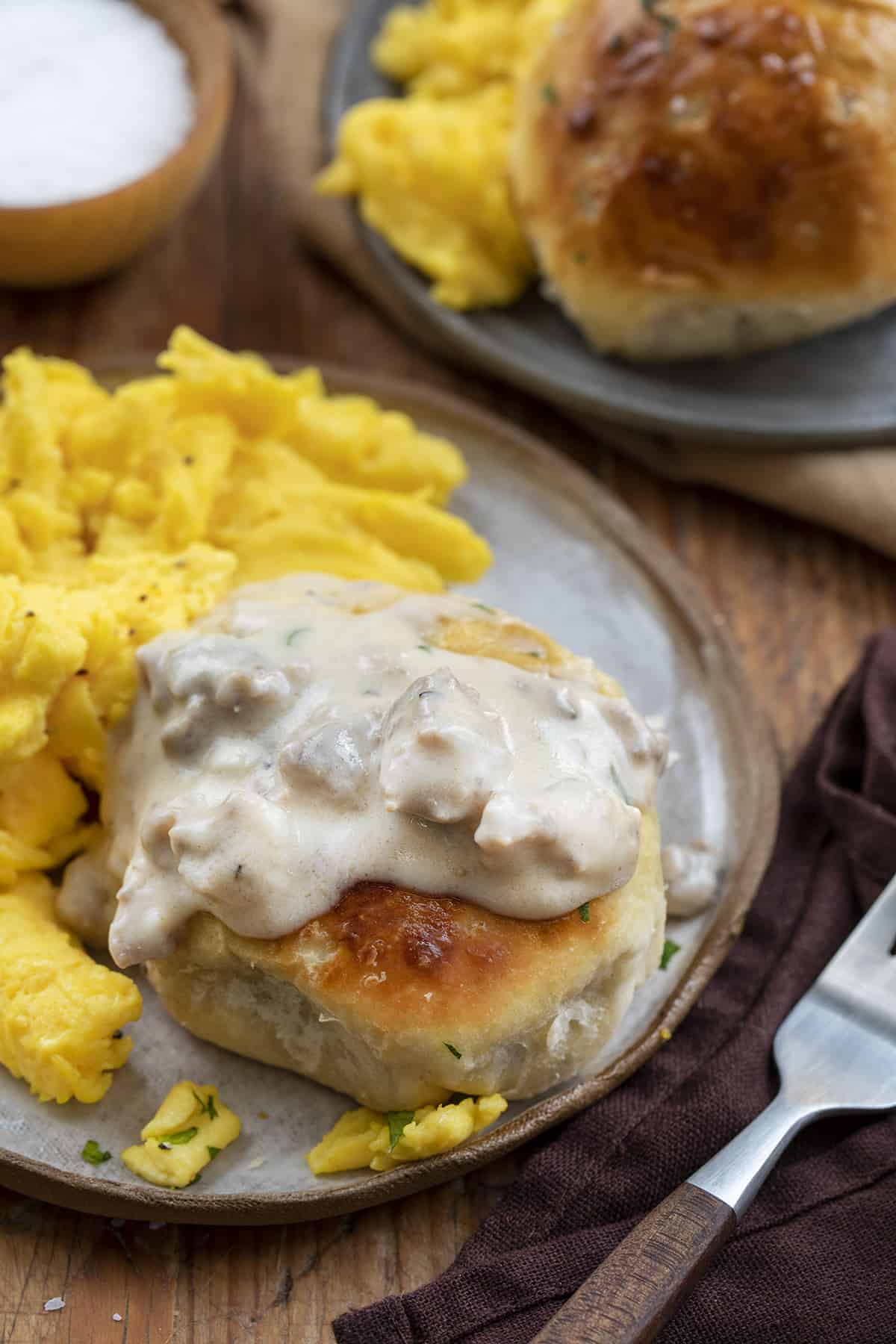 Biscuit and Gravy Bomb on a Plate with Sausage Gravy on top and Scrambled Eggs. Breakfast, Breakfast Recipes, Biscuits and Gravy, How to Make Sausage Gravy, Canned Biscuit Recipes, Biscuits and Gravy hand Pies, Breakfast Bombs, Gravy Inside Biscuit, Breakfast Ideas for Kids, Easy Breakfast for School Mornings, i am homesteader, iamhomesteader