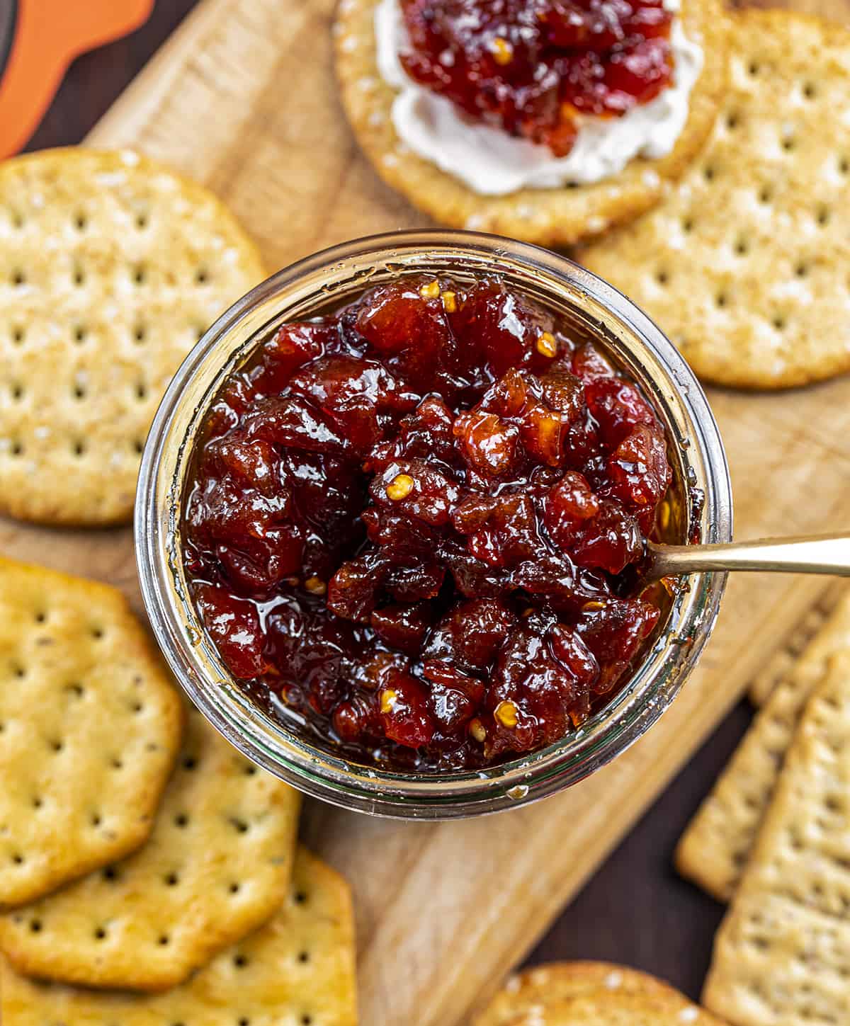 Jar of Spicy Tomato Jam with Crackers on a Cutting Board. Appetizer, Burger Topping Idea, Tomato Jam, How to Make Tomato Jam, Spicy Jam, Homemade Tomato Jam, How to Can Tomato Jam, Cracker Spreads, Super Bowl Food, Christmas Appetizers, Thanksgiving Appetizers, i am homesteader, iamhomesteader