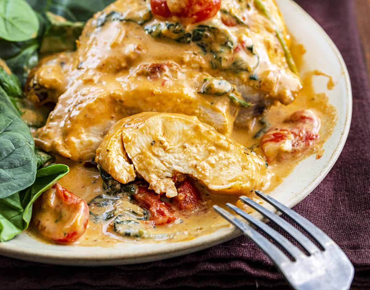 Skillet Tuscan Chicken Cut up on a Plate with a Fork Resting on the Plate. Dinner, Supper, Chicken Recipes, What to Cook for Dinner, Easy Chicken Recipe, How to Make Tuscan Chicken, What is Tuscan, Creamy Tomato Sauce Chicken, Kid Favorites Dinner, i am homesteader, iamhomesteader
