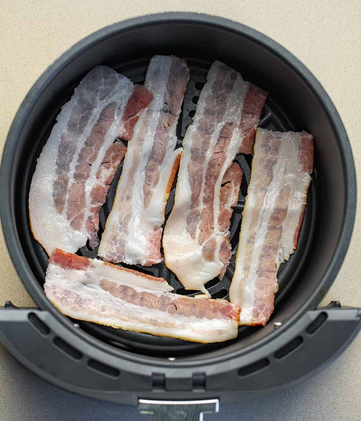 Raw Bacon in Air Fryer Basket Before Frying. Side Dish, How to Make Bacon, Crispy Bacon, Air Fryer Recipes, Breakfast, Breakfast bacon, Easy Bacon, Quick Bacon, i am homesteader, iamhomesteader
