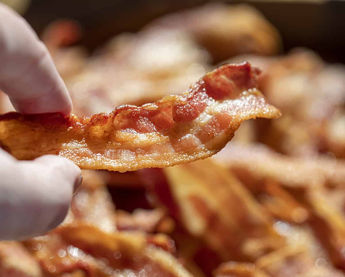 Hand Holding Piece of Crispy Bacon Made in an Air Fryer. Side Dish, How to Make Bacon, Crispy Bacon, Air Fryer Recipes, Breakfast, Breakfast bacon, Easy Bacon, Quick Bacon, i am homesteader, iamhomesteader