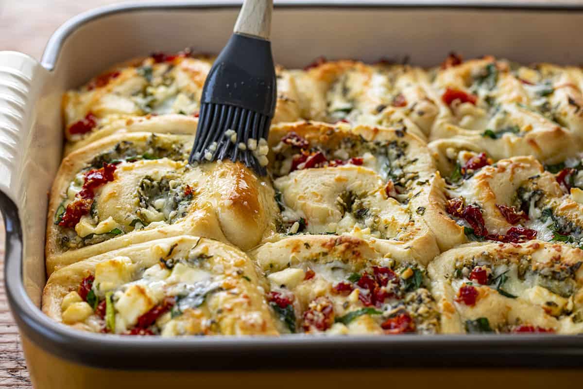 Pesto Feta Rolls Being Brushed with Butter. Rolls, Bread, Bread Recipes, Baking, Appetizer, Side Dish, Viral Recipes, i am homesteader, iamhomesteader