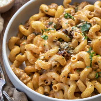 Bowl of Spicy Sausage Cavatappi with Basil Garnish on a Cutting Board. Dinner, Supper, Spicy Sausage Recipes, Dinner Recipes, Best Pasta Recipes, Pasta, Whats for Dinner, recipes, i am homesteader, iamhomesteader, viral tiktok