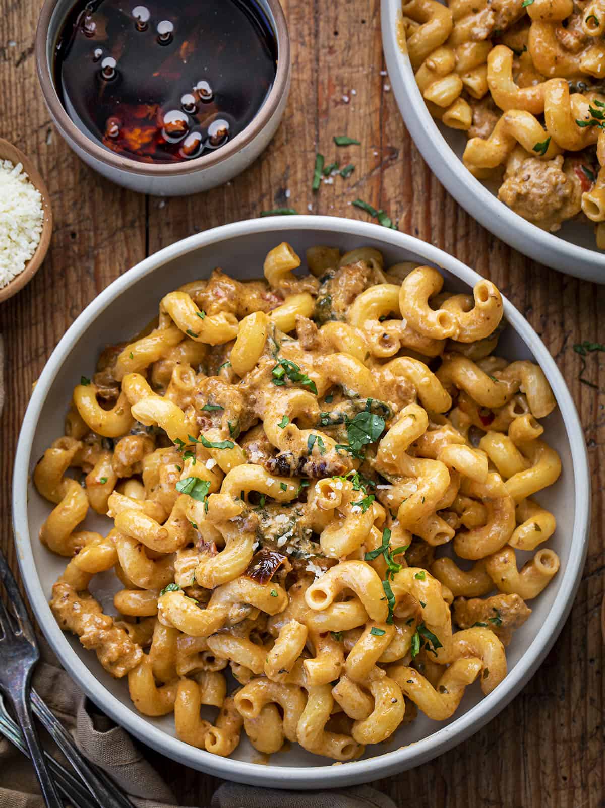 Bowls of Spicy Sausage Cavatappi on a Cutting Board with Parmesan and Sundried Tomatoes. Dinner, Supper, Spicy Sausage Recipes, Dinner Recipes, Best Pasta Recipes, Pasta, Whats for Dinner, recipes, i am homesteader, iamhomesteader, viral tiktok