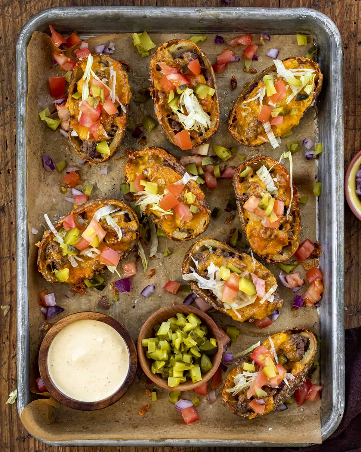Cheeseburger Potato Skins in a Pan with Dipping Sauce and Chopped Pickles. Appetizer, Potato Skins, How to Make Potato Skins, Cheeseburger Potato Skins, Super Bowl Food, Game Day Appetizer, Hot Appetizer, i am homesteader, iamhomesteader