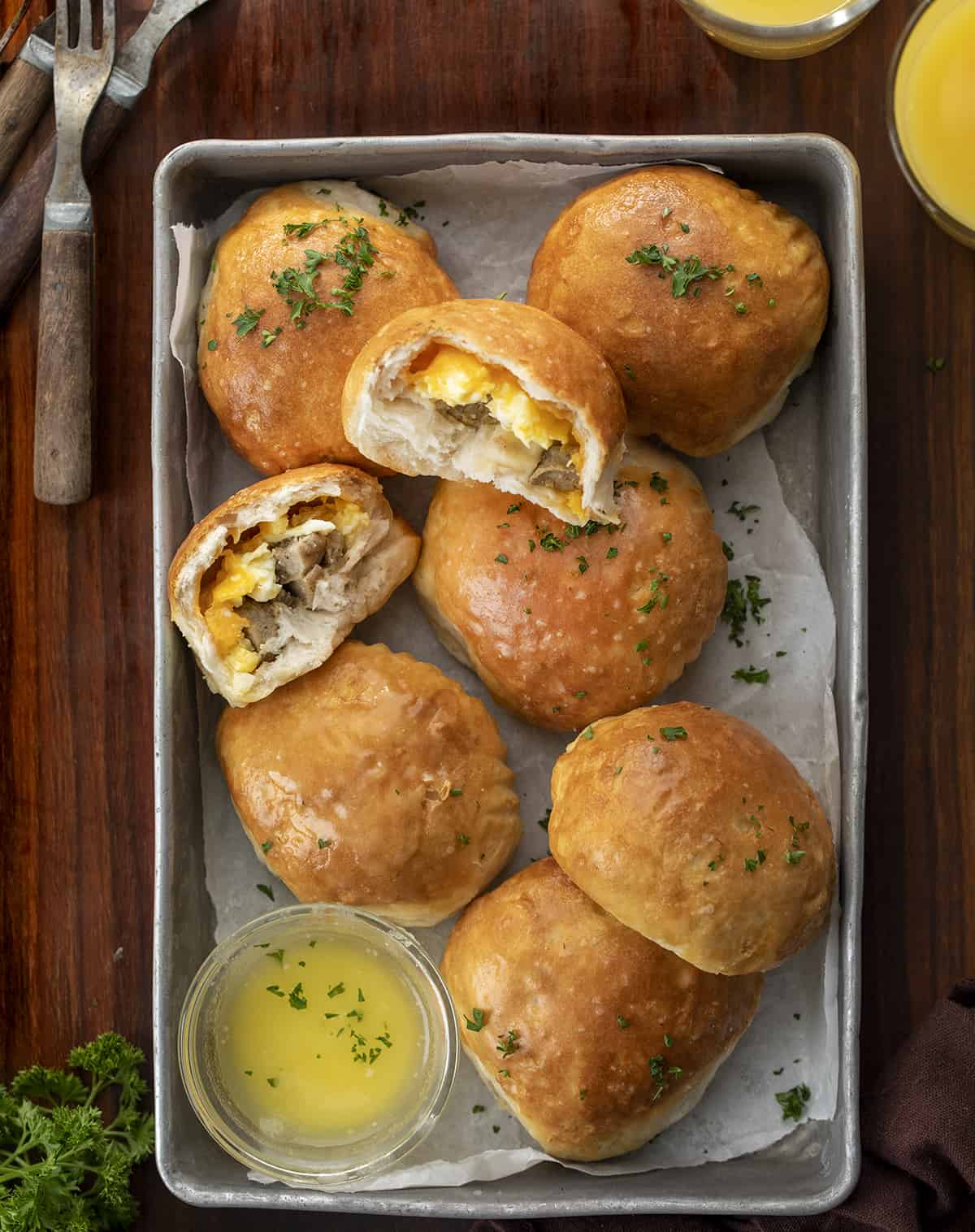 Pan of Breakfast Bombs with Melted Butter and Halved Breakfast Bomb Showing Inside. Breakfast, Easy Breakfast, Kid Breakfast, Breakfast Ideas, Sausage and Egg Breakfast, Sausage Egg Cheese Breakfast, Hot Breakfast, Brunch, Brunch IDeas, brunch recipes, i am homesteader, iamhomesteader
